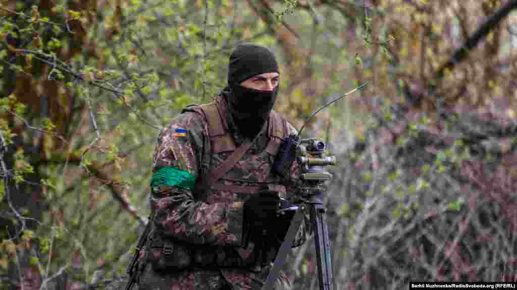 Український військовий працює з теодолітом перед нанесенням вогневого ураження по скупченню російських військ. Харьківська область, 20 квітня 2022 року&nbsp;